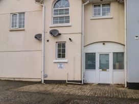 The exterior of a building with windows a door two satellite dishes and a parking area at 1 Ilsham Cottages in Torquay
