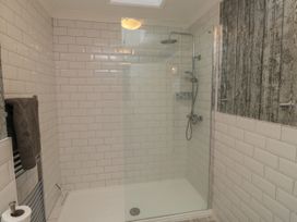 A shower area with white subway tiles and a glass shower screen at 1 Ilsham Cottages in Torquay