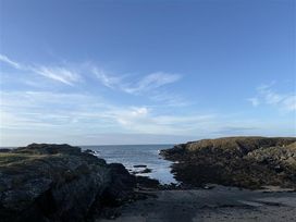 A view of the ocean with rocks and sandy area at Seaside Sanctuary in Trearddur Bay