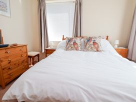 A bedroom with a bed and nightstand at Bryn Bach in Rhos-On-Sea