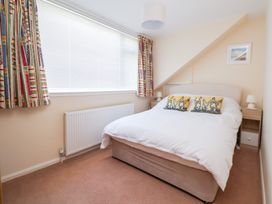 A bedroom with a bed and curtains at Bryn Bach in Rhos-On-Sea