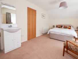 A bedroom with a bed, vanity unit, and chair at Bryn Bach in Rhos-On-Sea