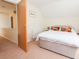 A bedroom with a bed and lamp at Bryn Bach in Rhos-On-Sea