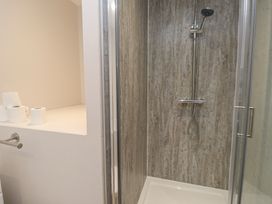 A shower with a showerhead and toilet paper in a bathroom at The Hideaway