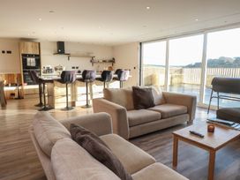 A living room with a sofa and kitchen area at The Hideaway in 
