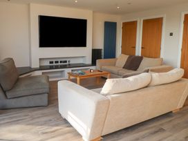 A living room with a television and seating at The Hideaway