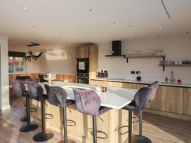 A modern kitchen with an island and bar stools at The Hideaway
