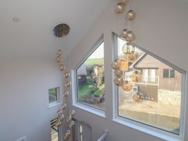 A staircase with a modern light fixture and large windows at The Hideaway