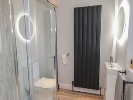 A bathroom with a shower, toilet, and sink at The Hideaway