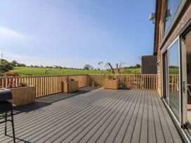 An outdoor deck with planters and a grill at The Hideaway in Mynytho near Abersoch