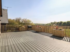 An outdoor deck with planters and a grill at The Hideaway in Mynytho near Abersoch