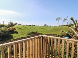 A view of sheep on grassland from a balcony at The Hideaway in Mynytho near Abersoch