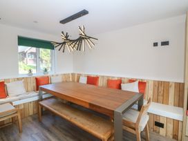 A dining room with a wooden table and benches at The Hideaway in Mynytho near Abersoch
