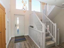 A hallway with stairs and a front door at The Hideaway in Mynytho near Abersoch