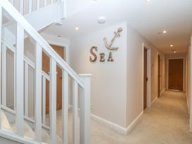 A hallway with a staircase and decorative anchor at The Hideaway in Mynytho near Abersoch