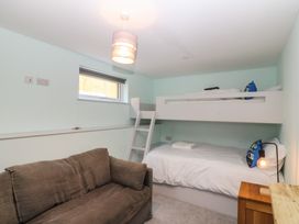 A bedroom with a bunk bed and a sofa at The Hideaway in Mynytho near Abersoch
