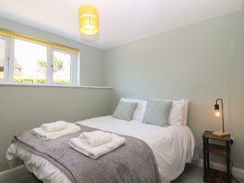 A bedroom with a bed and nightstand at The Hideaway in Mynytho near Abersoch