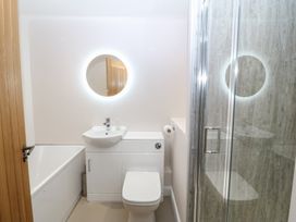 A bathroom with a bathtub, shower, sink, and toilet at The Hideaway in Mynytho near Abersoch
