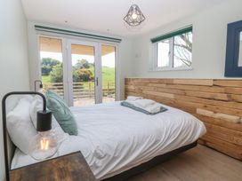 A bedroom with a bed and large windows at The Hideaway Mynytho near Abersoch