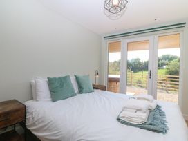 A bedroom with a bed and sliding doors at The Hideaway in Mynytho near Abersoch