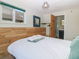 A bedroom with a bed and an adjoining bathroom at The Hideaway Mynytho near Abersoch