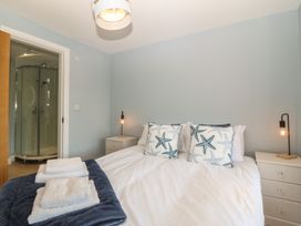 A bedroom with a bed and a shower at The Hideaway in Mynytho near Abersoch