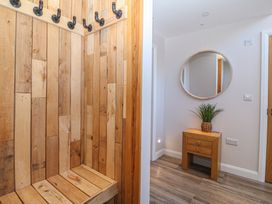 A hallway with coat hooks and a wooden bench at The Hideaway in Mynytho near Abersoch