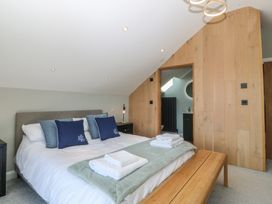 A bedroom with a bed, towels on the bed, and a door at The Hideaway in Mynytho near Abersoch