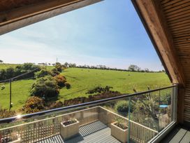 A view from a balcony overlooking fields and cattle at The Hideaway Mynytho near Abersoch