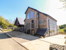 A wooden house with a gravel driveway and steps at The Hideaway in Mynytho near Abersoch