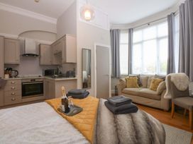 A studio apartment with a kitchen and seating area at Queens Park in Llandudno