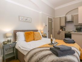 A bedroom with a bed and a kitchenette at Queens Park in Llandudno