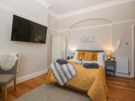 A bedroom with a bed and television at Queens Park in Llandudno