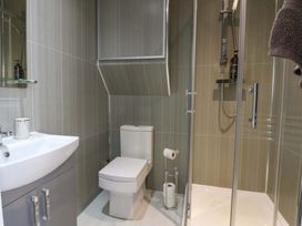 A bathroom with a shower, sink, and toilet at Queens Park in Llandudno