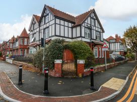 A house with a fence and street sign at Queens Park in Llandudno