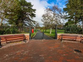 A pathway with benches and trees at Queens Park in Llandudno