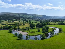 A landscape featuring a river winding through fields and trees at Hay Store in Corwen