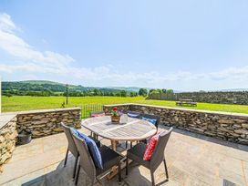 An outdoor dining area with a table and chairs at Hay Store in Corwen