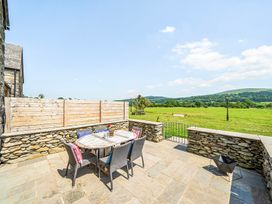 An outdoor patio with a table and chairs at Hay Store in Corwen