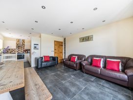 A living room with sofas and a kitchen area at Hay Store in Corwen