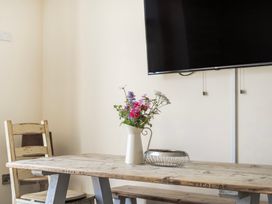 A dining room with a table and flowers at Hay Store in Corwen