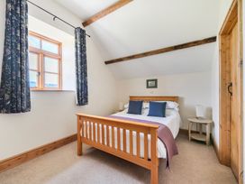 A bedroom with a bed and window at Hay Store in Corwen