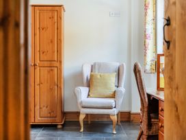A living room with an armchair and wardrobe at Hay Store in Corwen