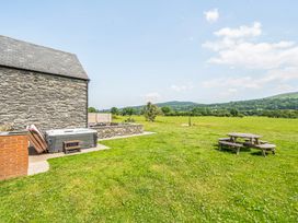 An outdoor area with a stone building and picnic table at Hay Store in Corwen