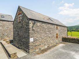A stone building with windows and a sign at Hay Store in Corwen