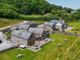 A view of multiple buildings and green space at The Barn in Corwen