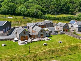 An outdoor space with multiple buildings and a garden at The Barn in Corwen