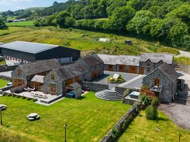 An outdoor view of a property with stone buildings and garden at The Barn in Corwen