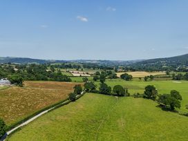 A landscape with fields and trees at The Barn in Corwen