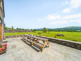 An outdoor space with a picnic table and views of grass at The Barn in Corwen
